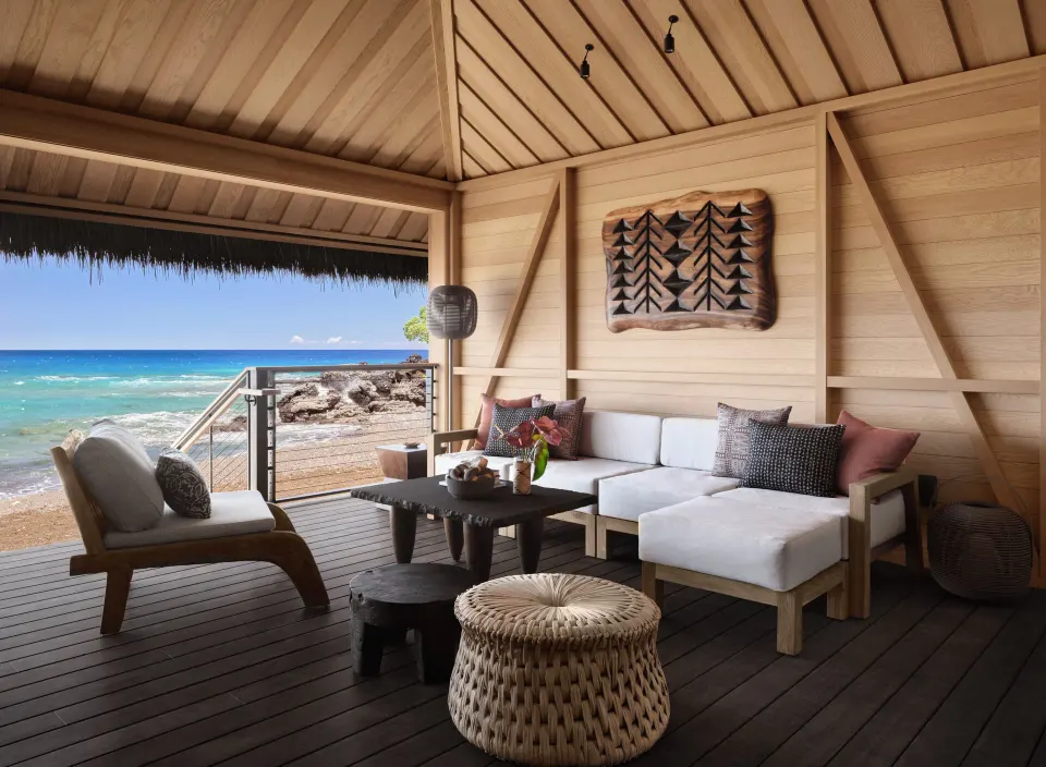 Covered lanai seating with ocean and rocky shore views at Kona Village.