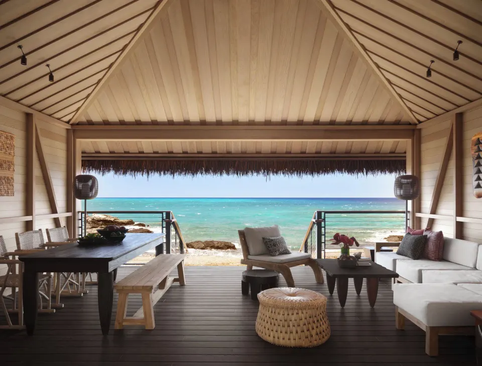 Spacious covered lanai with dining and lounge areas facing the ocean at Kona Village.