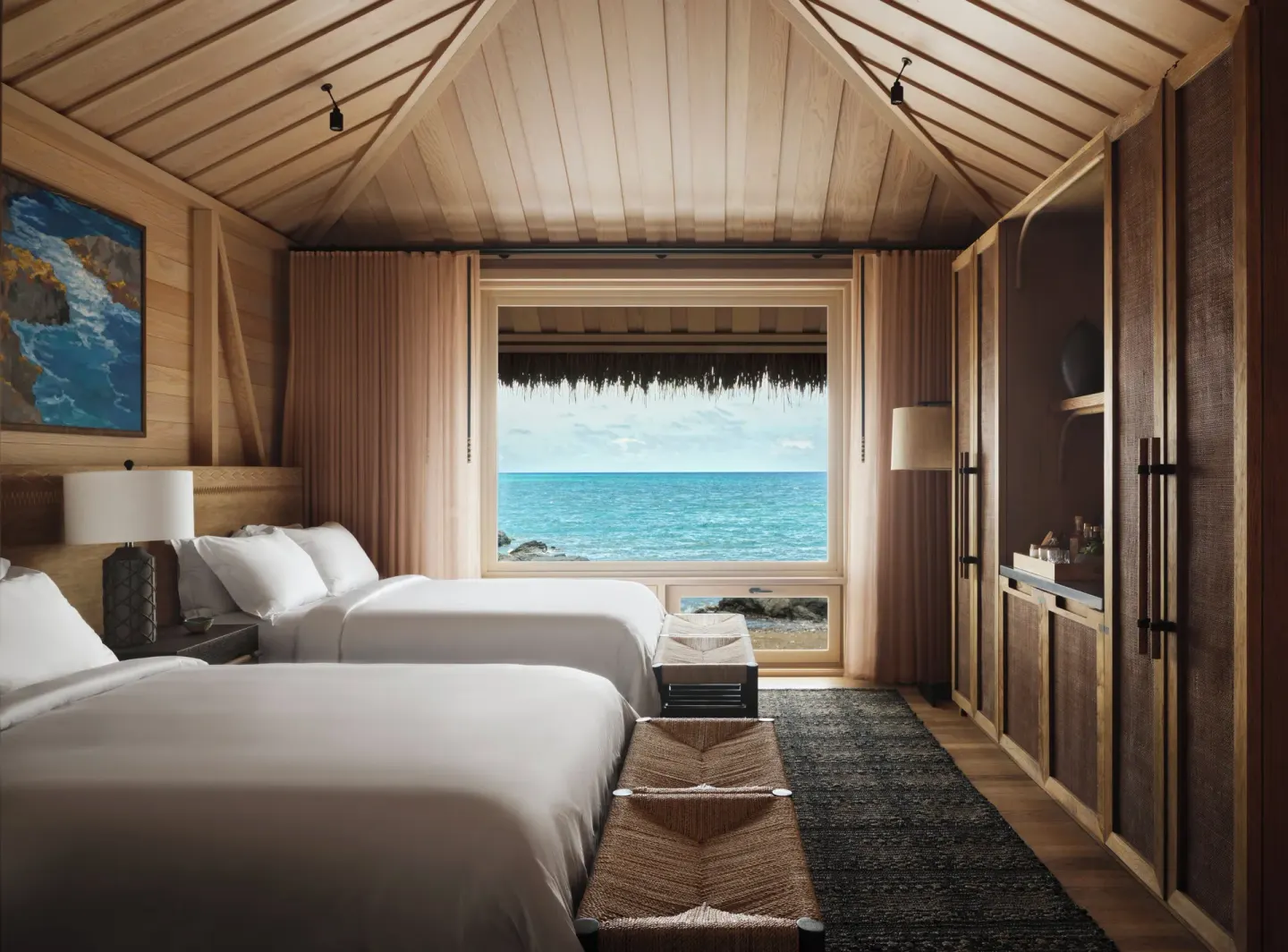 Two-bed guest room with ocean-facing window at Kona Village.