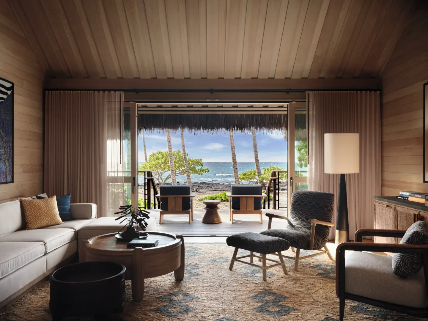 Beach Front One Bedroom Kauhale living room opening to the ocean at Kona Village.