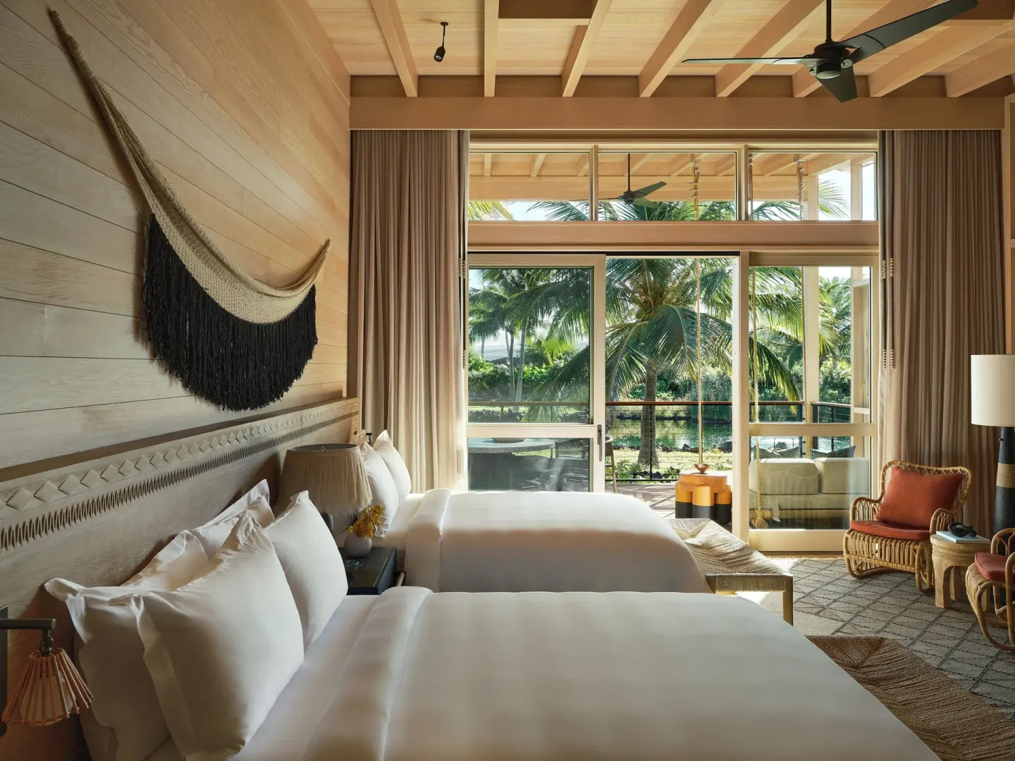 Two beds and a palm-view lanai in a Mountain View Two Bedroom Kauhale at Kona Village.