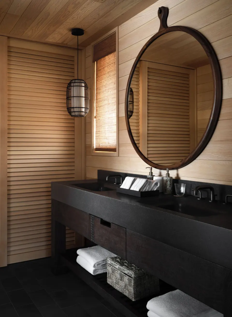Double vanity with round mirror in the Ocean Front Black Sand Two Bedroom Kauhale at Kona Village.