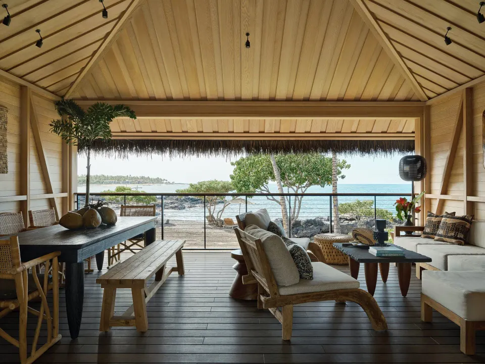 Lanai dining and lounge areas in an Ocean Front Black Sand Two Bedroom Kauhale at Kona Village.