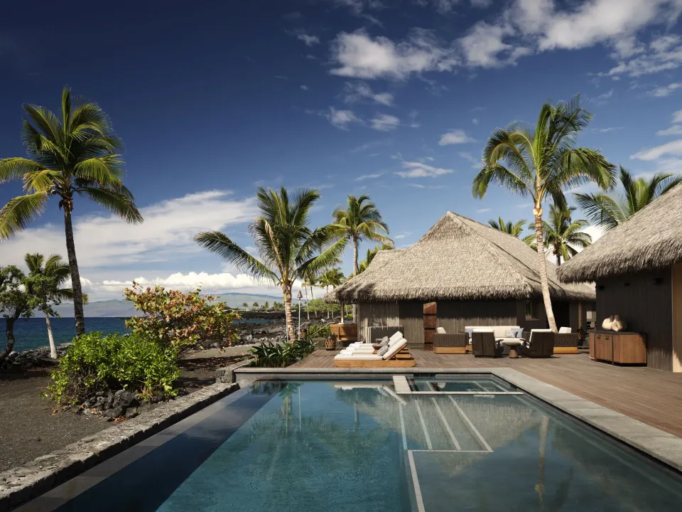Oceanfront pool and thatched hale at the Ocean Front Four Bedroom Maheawalu Kauhale at Kona Village.