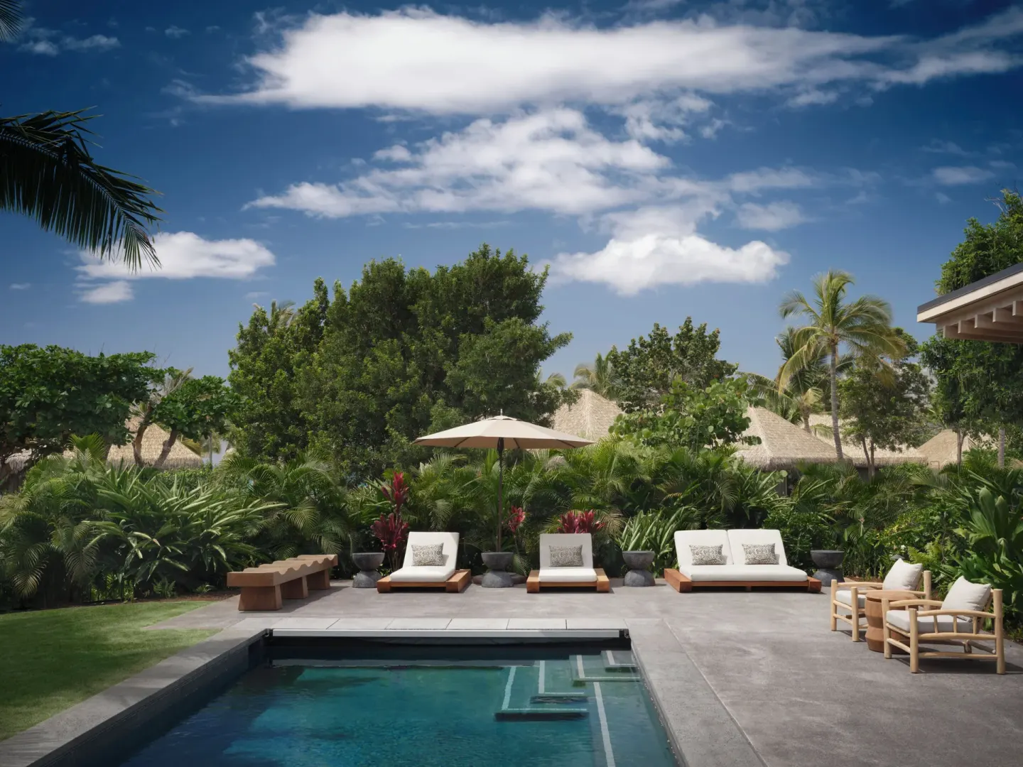 Private pool terrace with loungers at the Ocean Front Four Bedroom Maheawalu Kauhale at Kona Village.