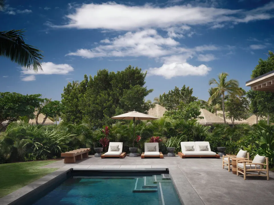 Private pool terrace with loungers at the Ocean Front Four Bedroom Maheawalu Kauhale at Kona Village.