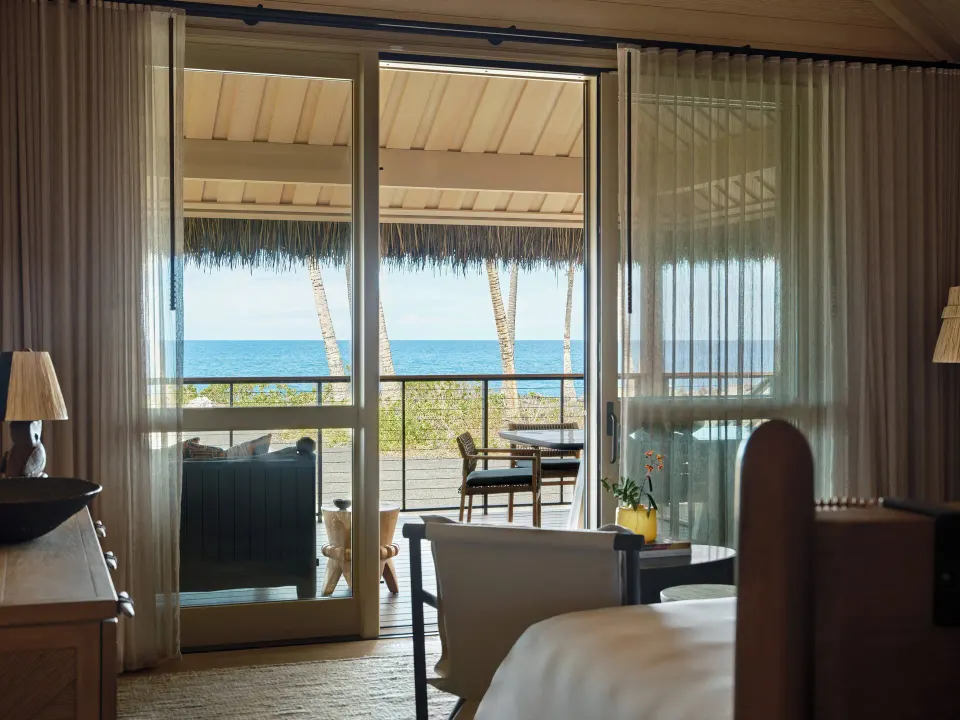 Ocean Front One Bedroom Kauhale bedroom opening to an ocean-facing lanai at Kona Village.