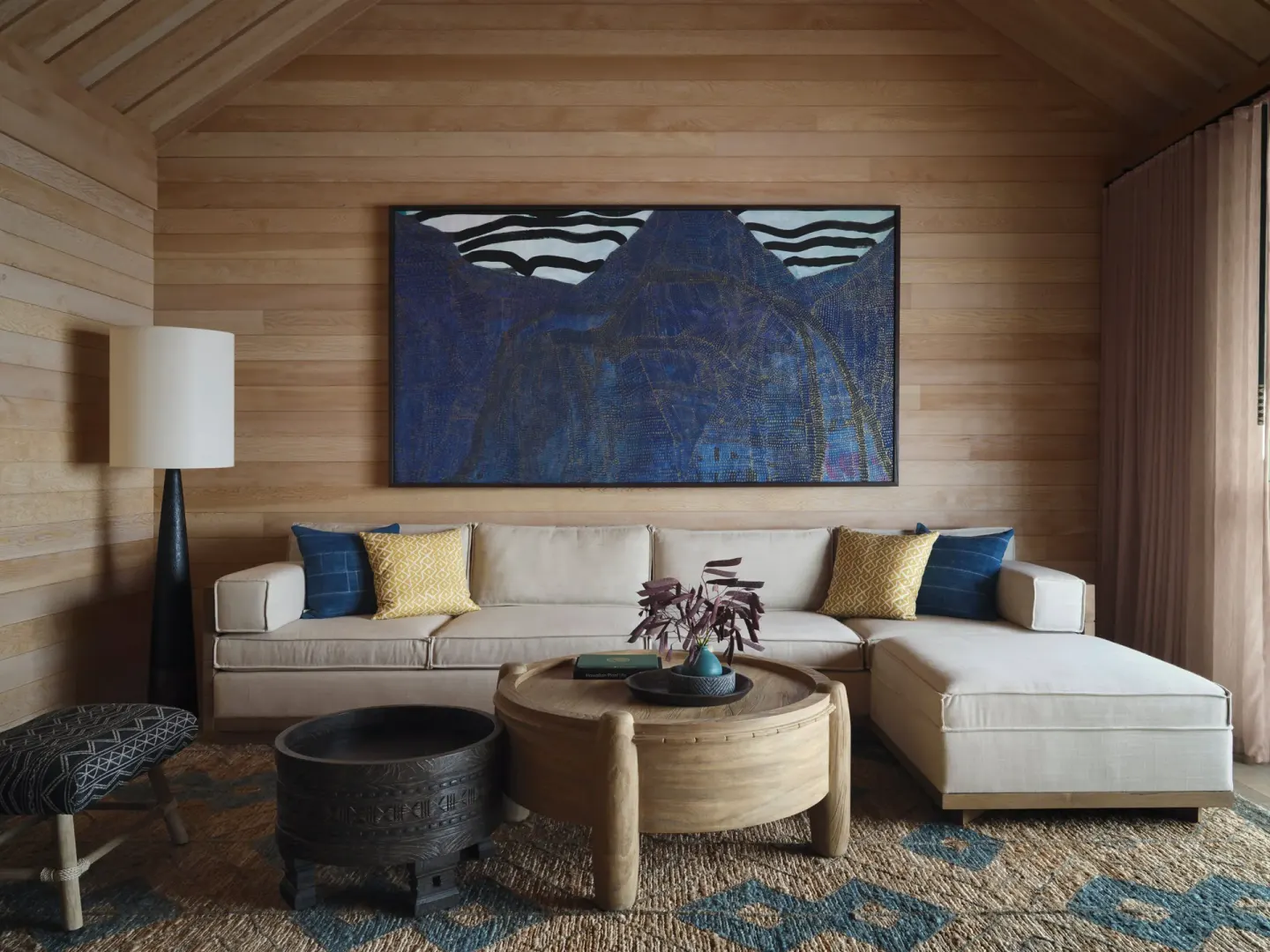 Living area in an Ocean View Accessible One Bedroom Kauhale at Kona Village with sofa and wood walls.