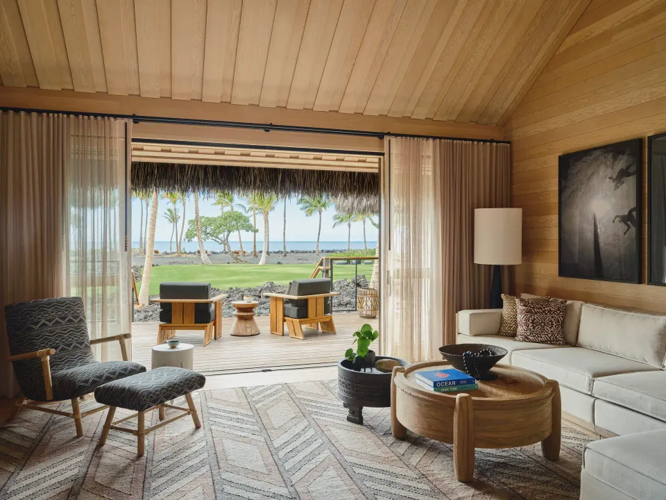 Ocean View One Bedroom Kauhale living room opens to a lanai and ocean at Kona Village.