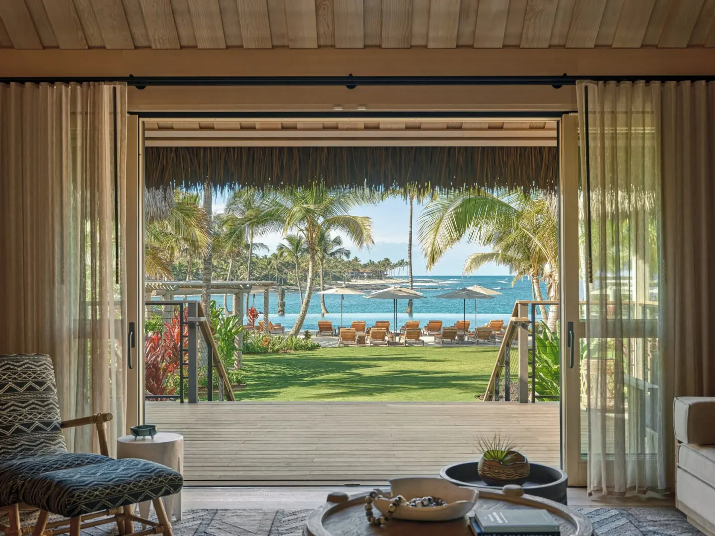 Ocean View One Bedroom Kauhale sitting area frames the beach and ocean at Kona Village.