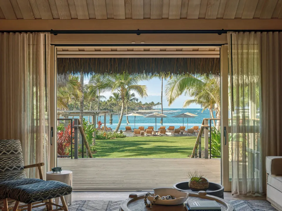 Ocean View One Bedroom Kauhale sitting area frames the beach and ocean at Kona Village.