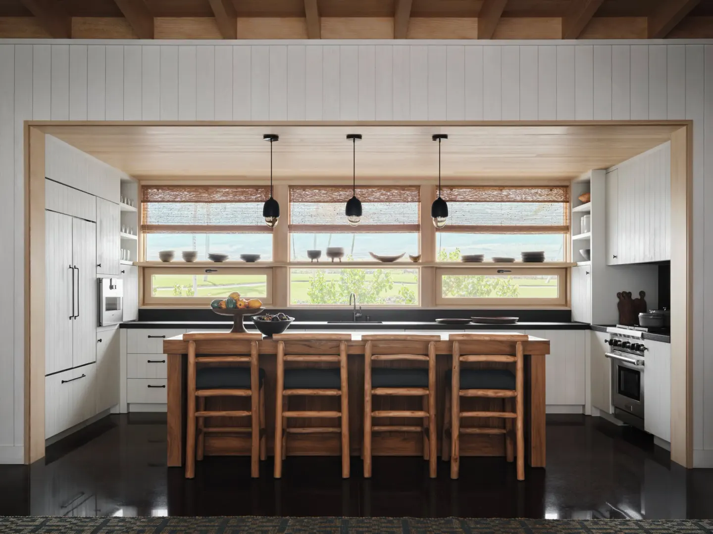 Kitchen with island seating in the Ohana Pool Accessible Four Bedroom Kauhale at Kona Village.