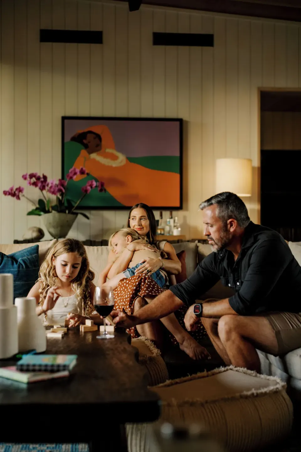Family relaxing on a sofa in the Kona Village kauhale living room.