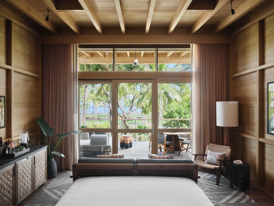 Tree Top Hale king bed and balcony view through glass doors at Kona Village.
