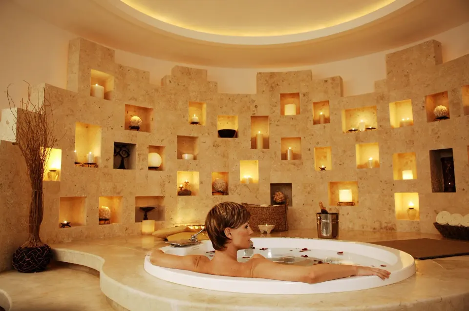 Spa tub with candlelit stone wall niches at Krystal Cancun.