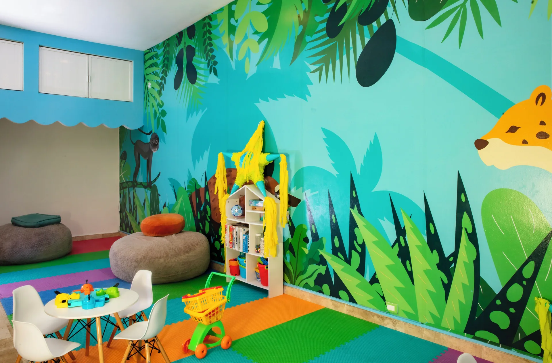 Kids club corner with jungle mural, beanbags, and play furniture at Krystal Cancun.