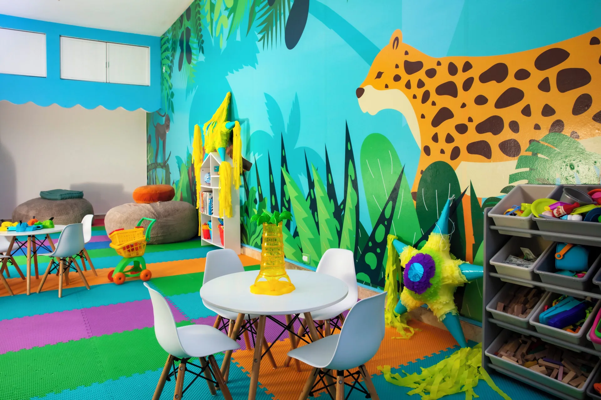 Colorful kids club playroom with jungle mural and toys at Krystal Cancun.