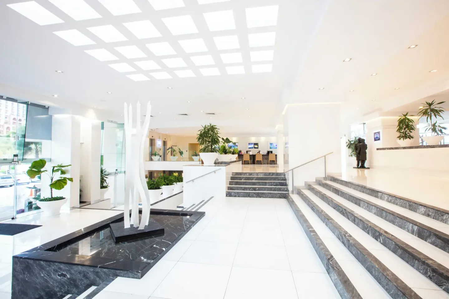 Lobby stairs, glass entry and sculptural centerpiece at Krystal Cancun.