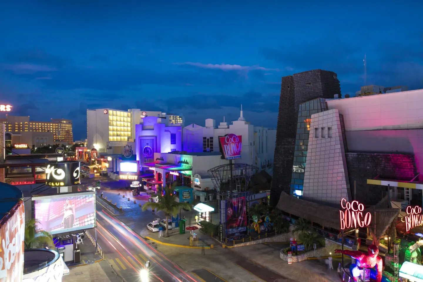 Cancun nightlife district near Krystal Cancun with bright signs and evening traffic.