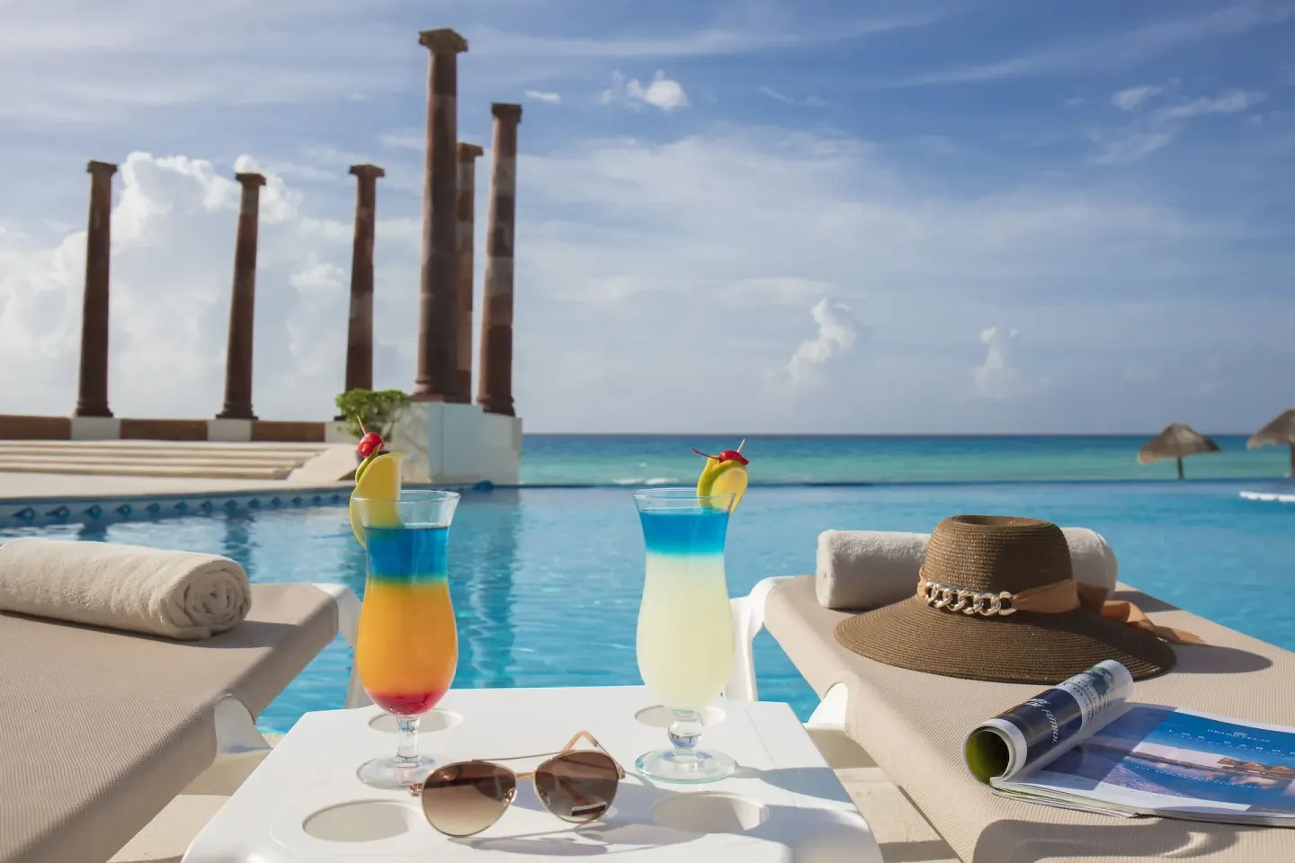 Poolside drinks, loungers, and ocean views at Krystal Cancun.