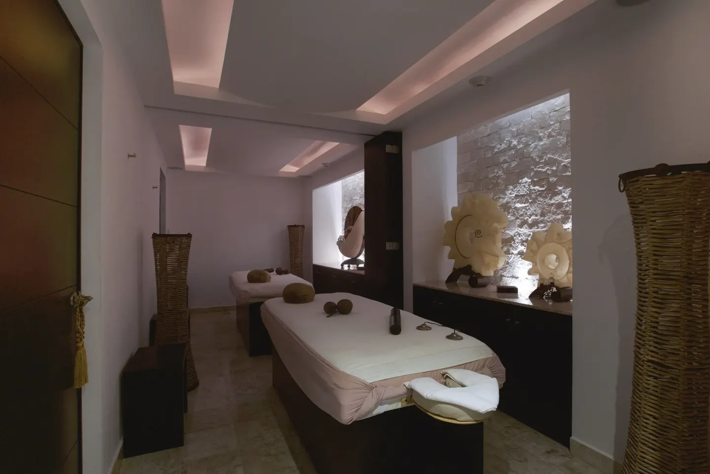 Spa treatment room with massage tables and shell decor at Krystal Cancun.
