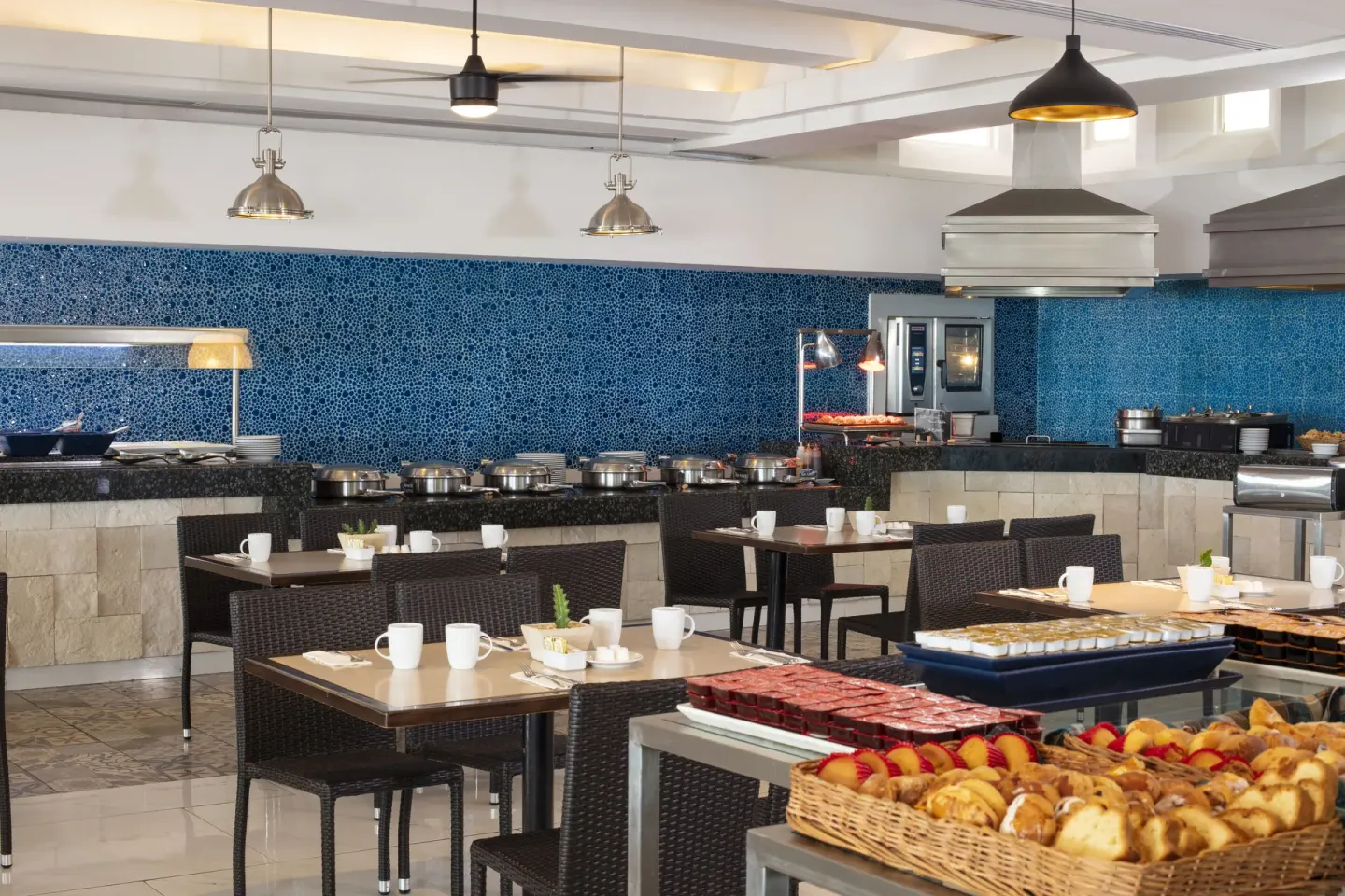 Buffet dining room with blue tile wall and breakfast pastries at Krystal Cancun.