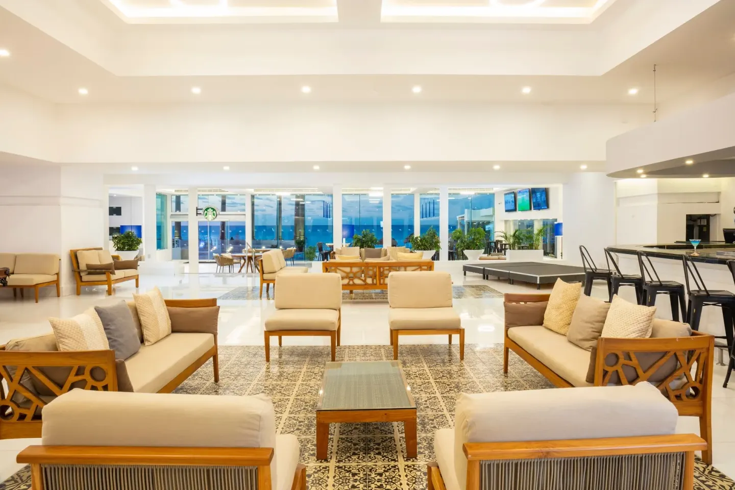 Sofas, armchairs and bar area in a bright lounge at Krystal Cancun.