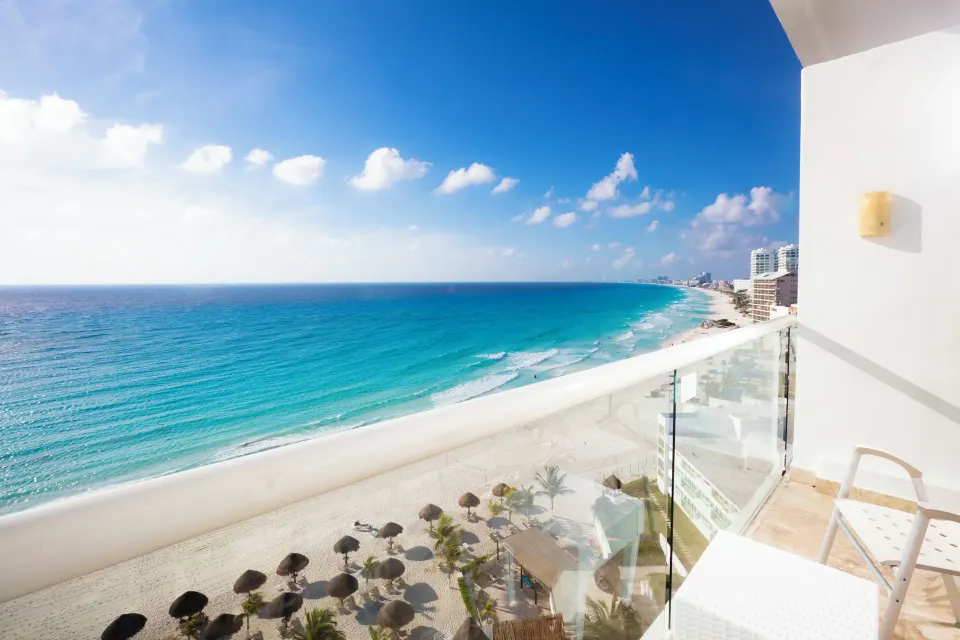 Club Room balcony with chairs and sweeping beach ocean view at Krystal Cancun.