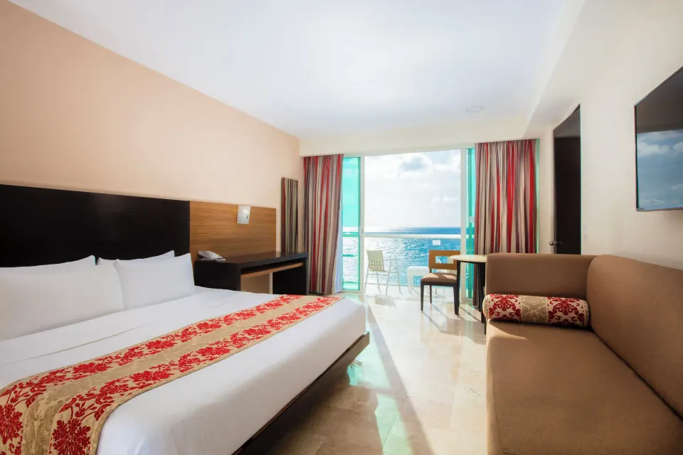 Club Room with king bed, sofa, and balcony ocean view at Krystal Cancun.
