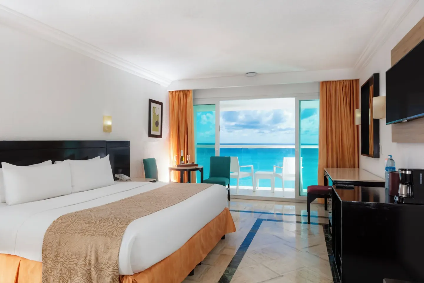 Deluxe ocean view king room with balcony seating at Krystal Cancun.