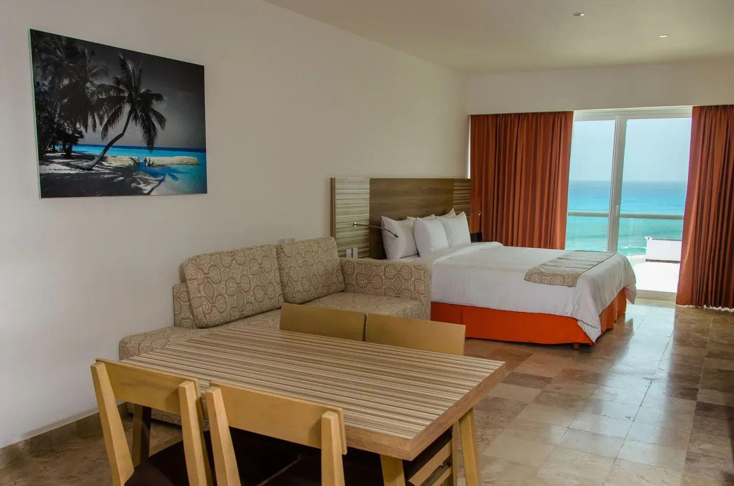 Family Studio with sofa bed, dining table, bed, and ocean-facing balcony at Krystal Cancun.