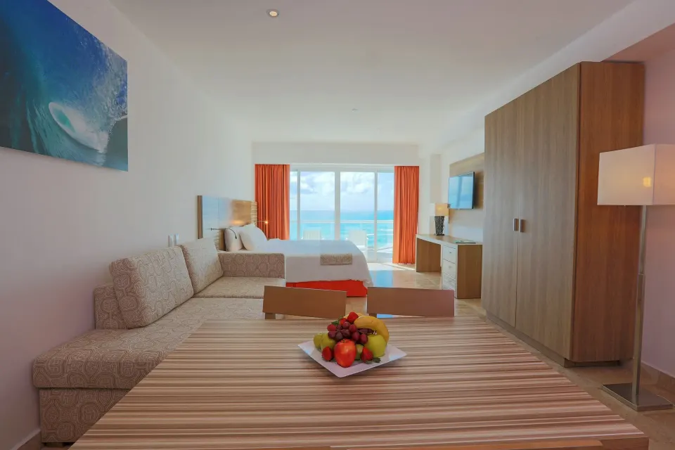 Family Studio dining table, sofa bed, bed, and ocean view at Krystal Cancun.