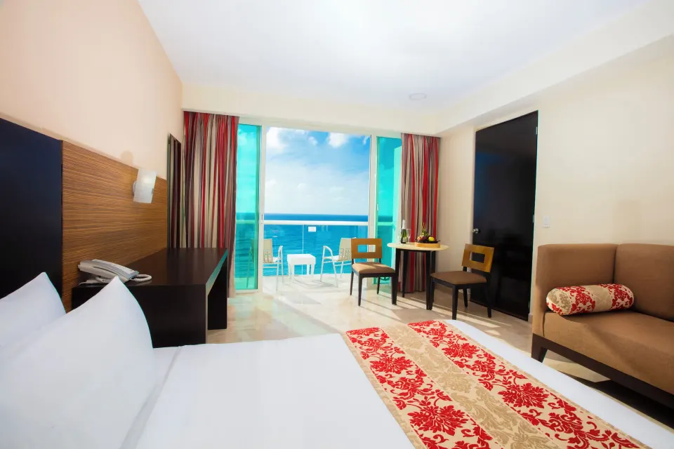Romantic Room with king bed, sofa, balcony, and ocean view at Krystal Cancun.