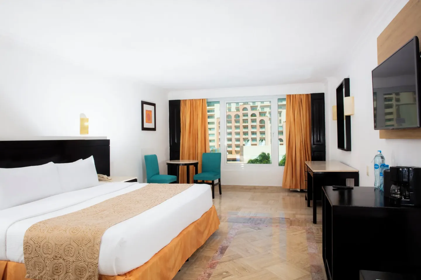 Standard Room with king bed, window seating, wall TV, and city-facing window at Krystal Cancun.