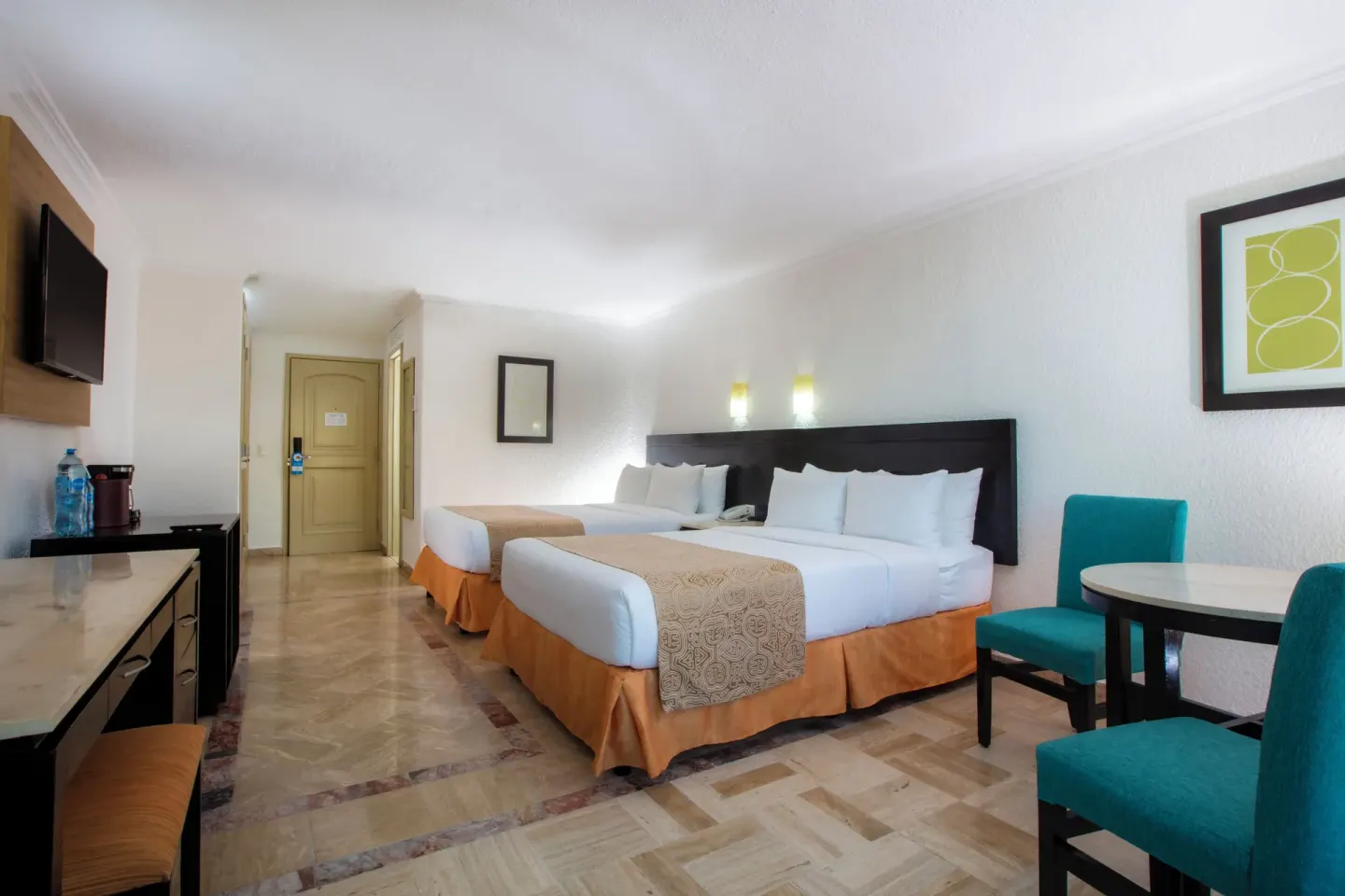 Standard Room with two beds, dining table, desk, and wall TV at Krystal Cancun.