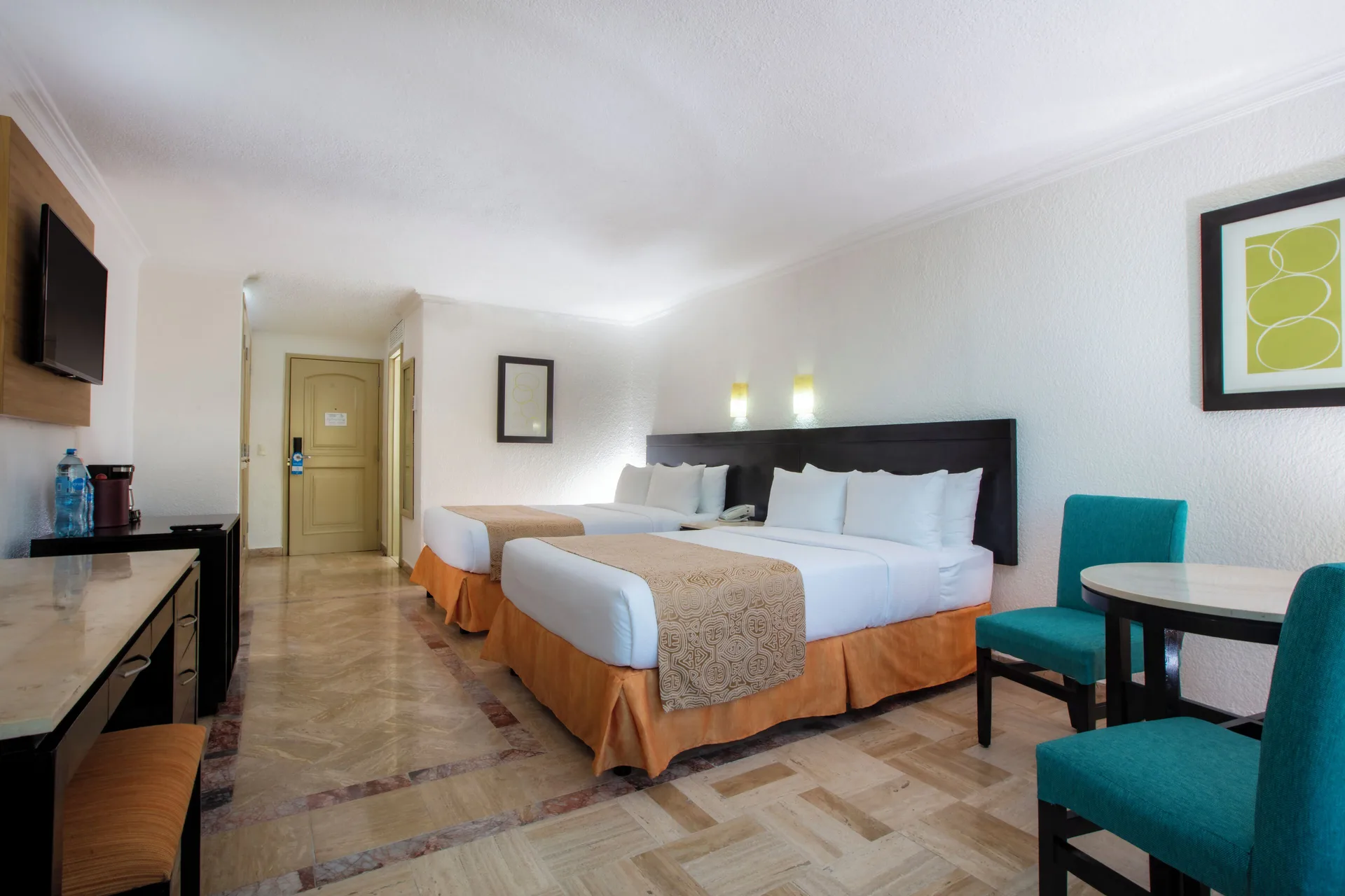 Standard Room with two beds, dining table, desk, and wall TV at Krystal Cancun.