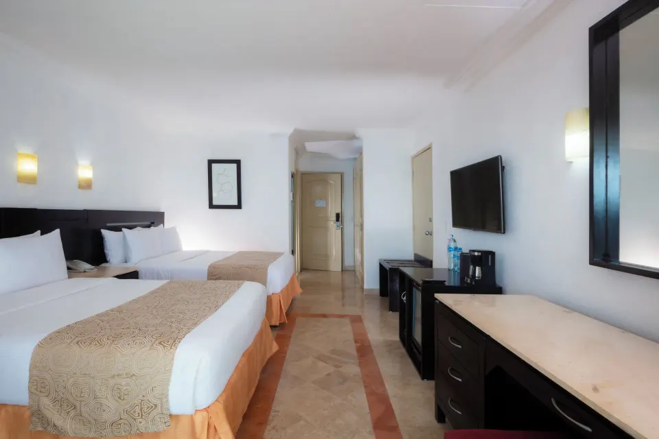 Standard Room with two beds, desk, mirror, TV, and beverage station at Krystal Cancun.