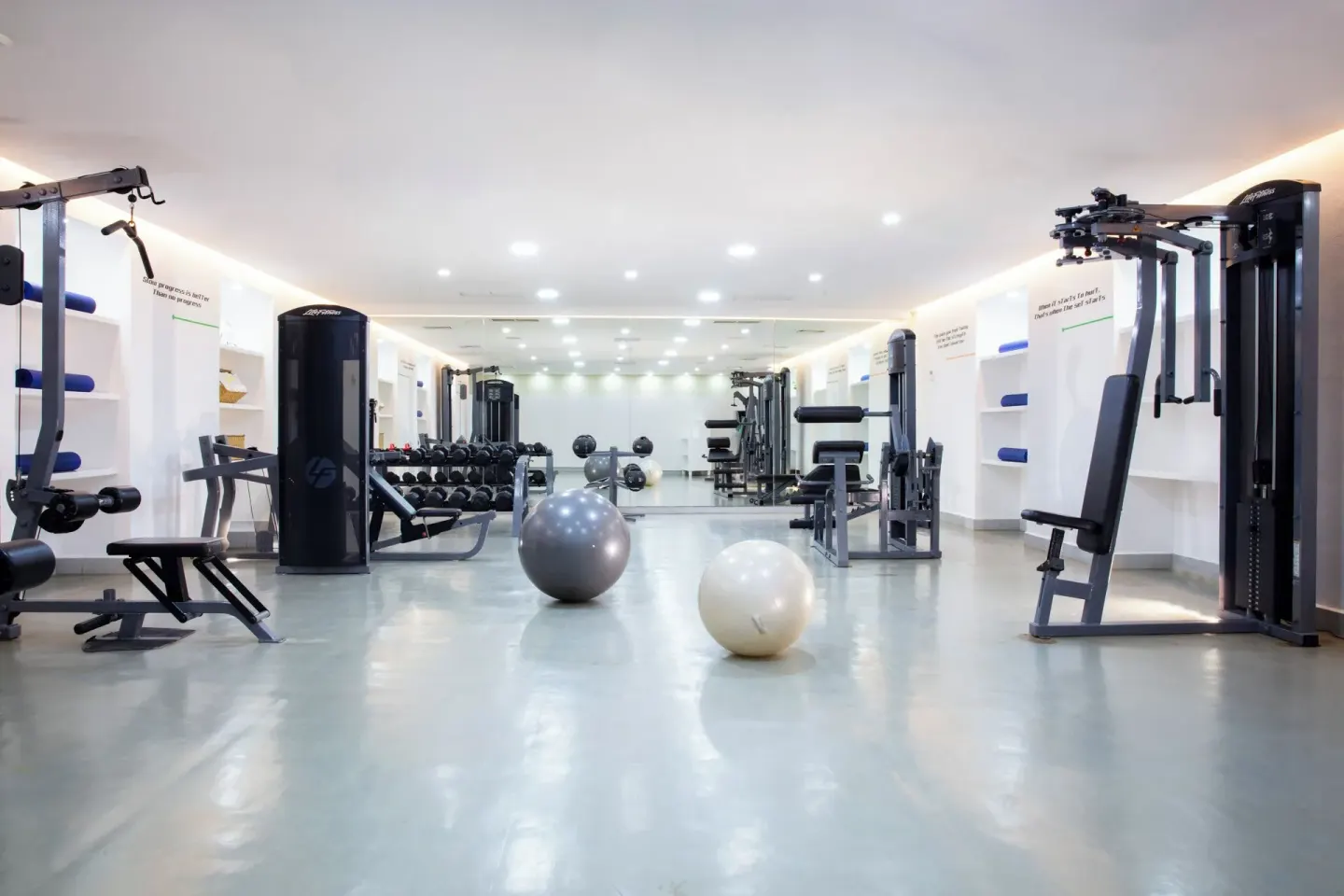 Fitness center with strength machines, weights, and exercise balls at Krystal Grand Cancun.