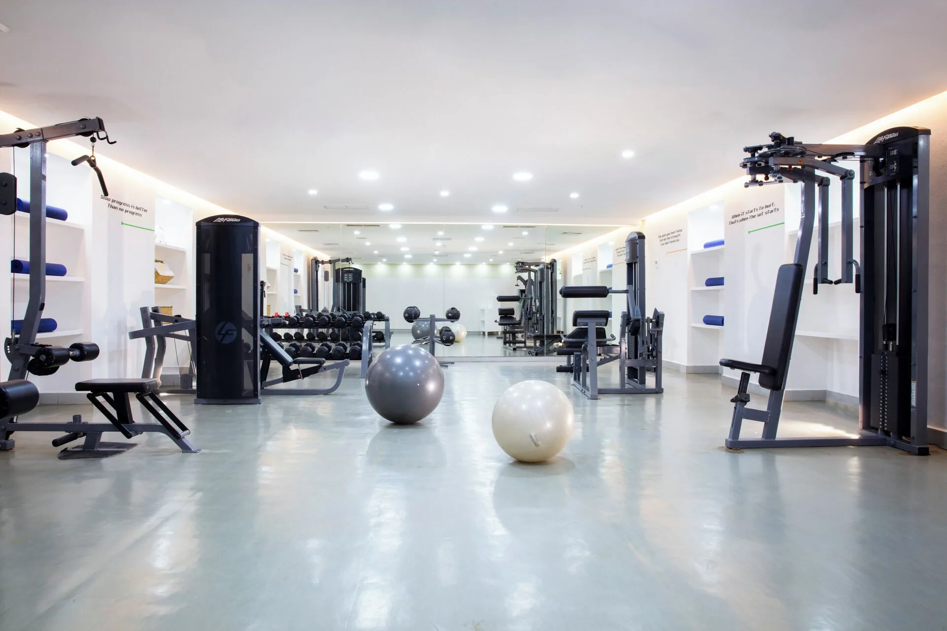 Fitness center with strength machines, weights, and exercise balls at Krystal Grand Cancun.
