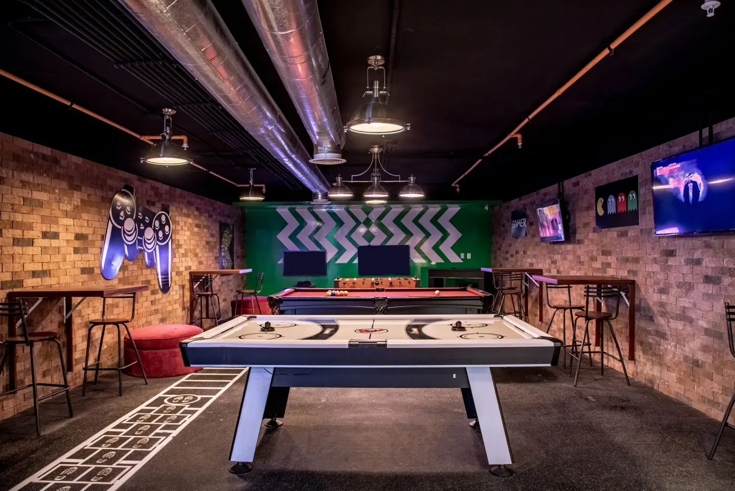 Game room with air hockey, pool table and screens at Krystal Grand Cancun.