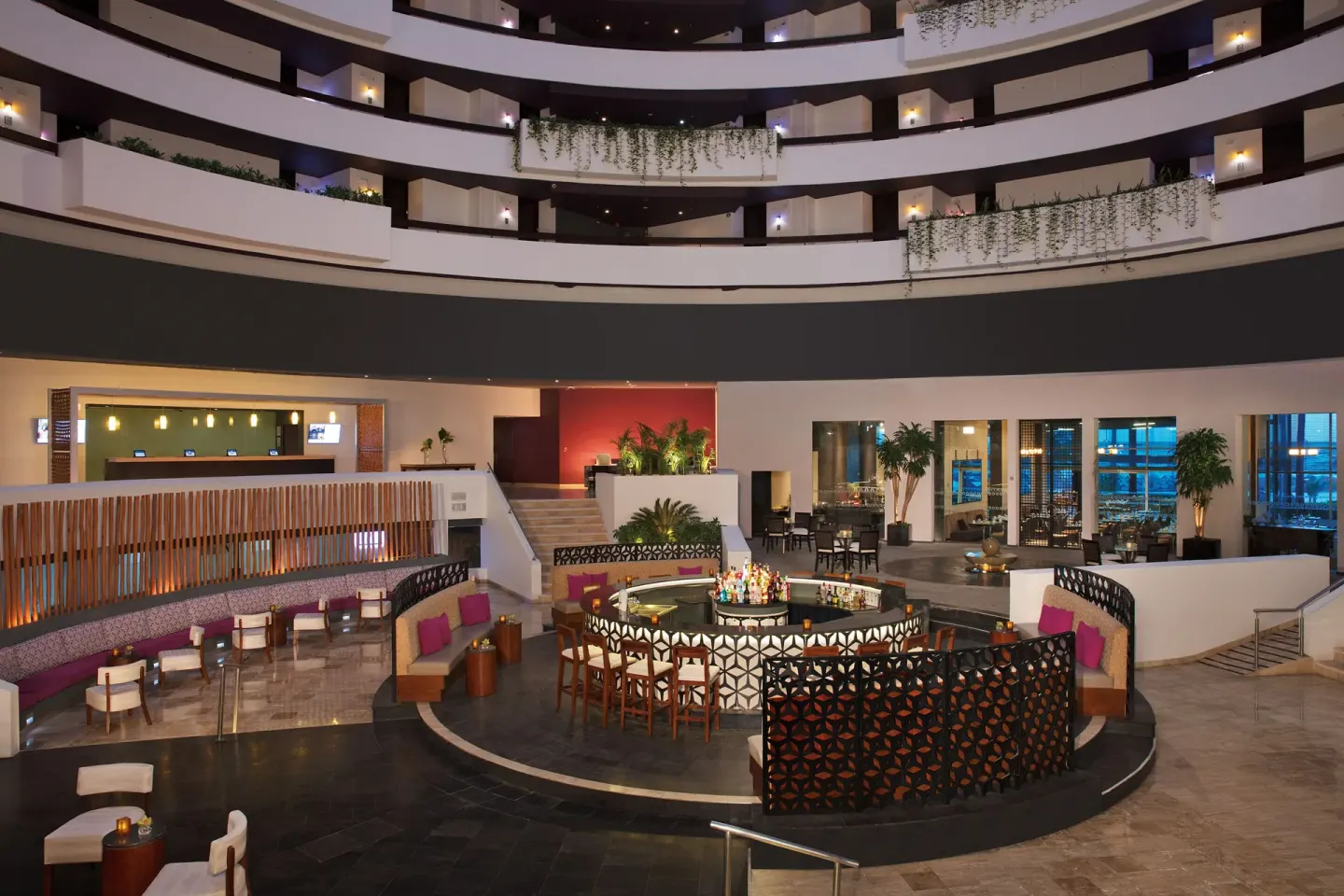 Atrium lobby bar with circular counter and seating at Krystal Grand Cancun.