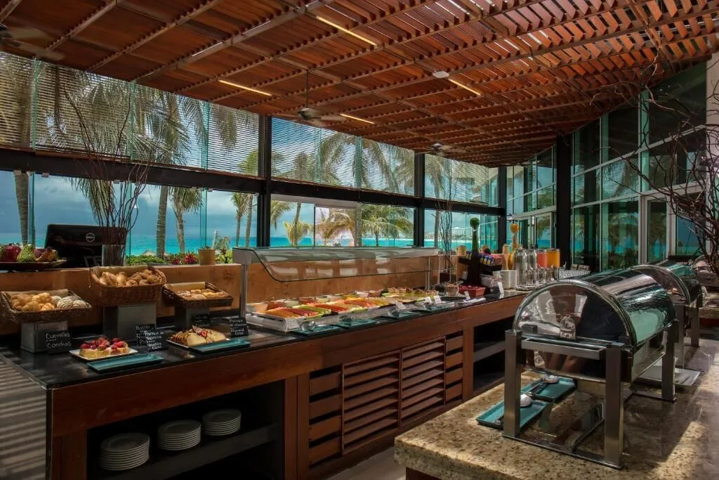 Breakfast buffet counter with pastries, fruit, and ocean views at Krystal Grand Cancun.