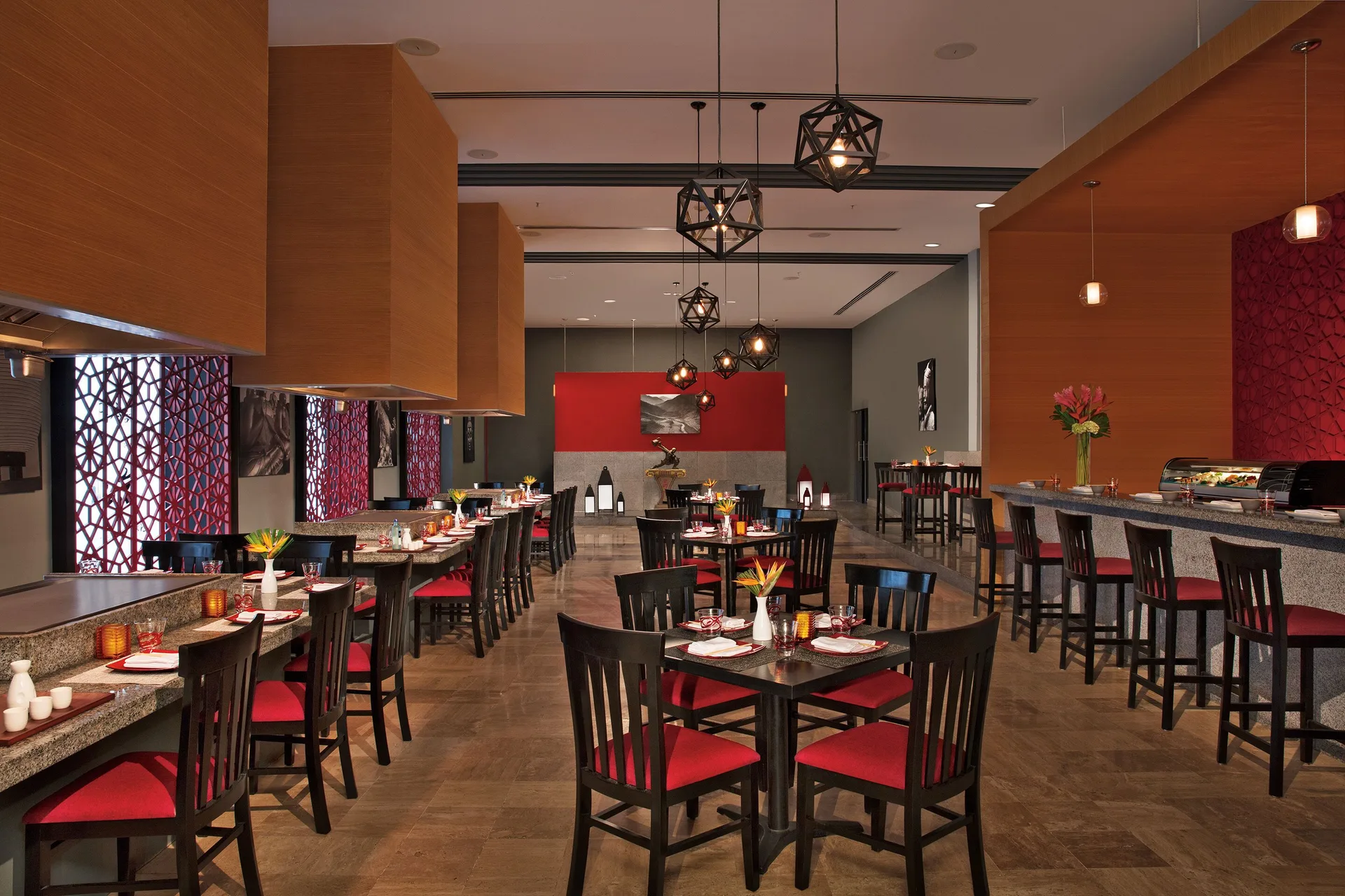 Restaurant dining room with red chairs and set tables at Krystal Grand Cancun.