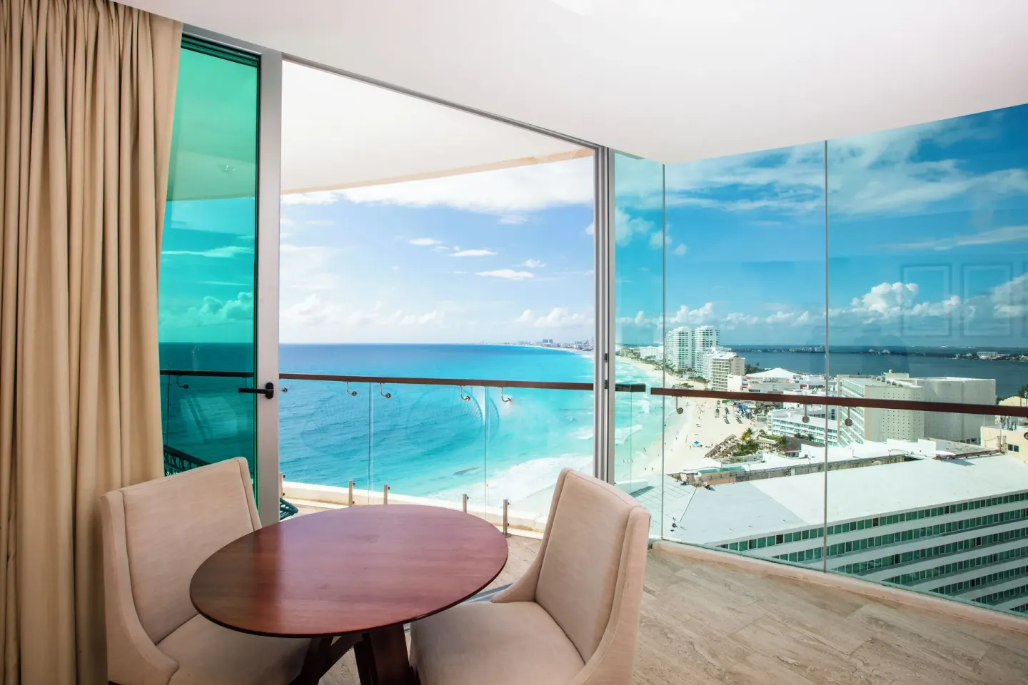 Altitude Corner Suite table by panoramic beach and city views at Krystal Grand Cancun.