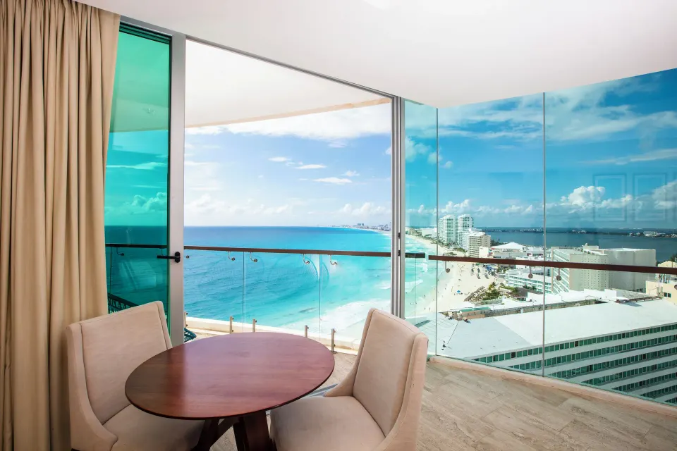 Altitude Corner Suite table by panoramic beach and city views at Krystal Grand Cancun.