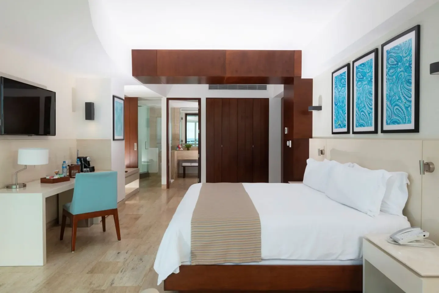 Altitude Corner Suite king bed with desk, wardrobe, and bathroom entry at Krystal Grand Cancun.