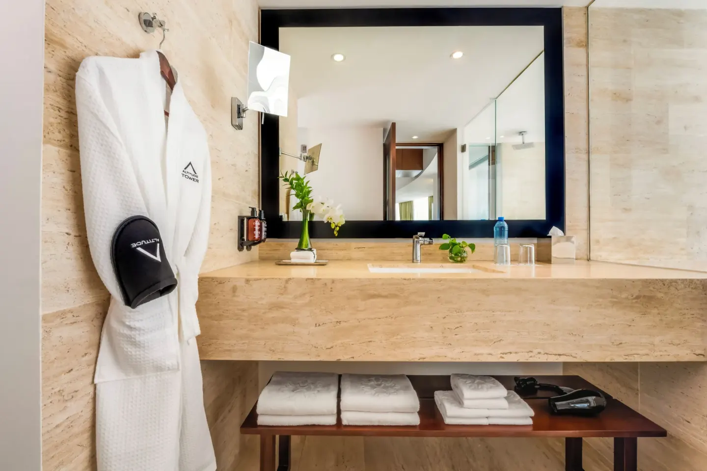 Altitude Suite bathroom vanity with robe and towels at Krystal Grand Cancun.