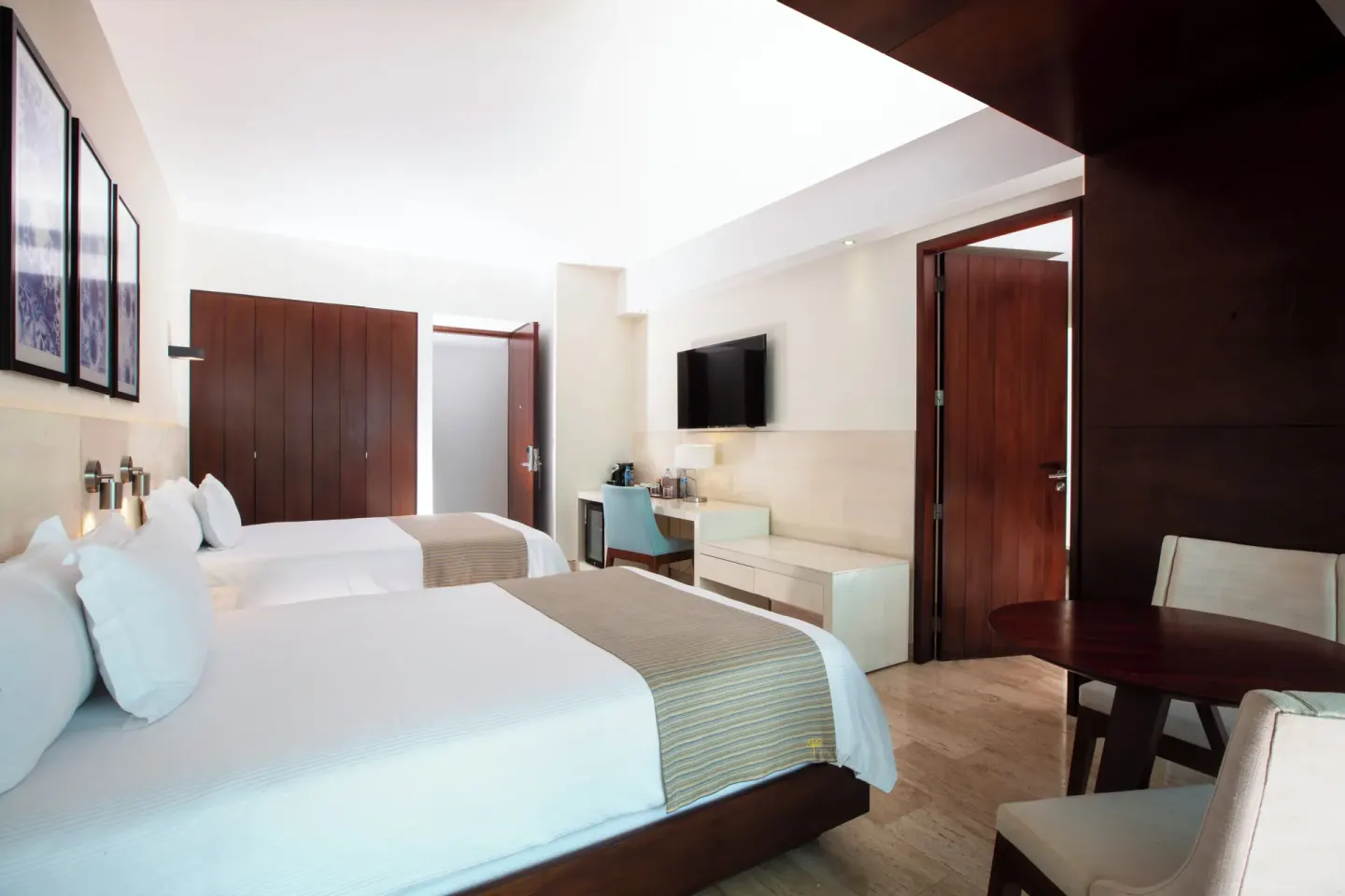 Two double beds and a work desk in an Altitude Suite Boulevard View at Krystal Grand Cancun.