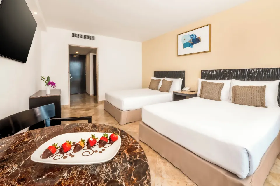Deluxe Room Ocean View two double beds and dessert plate at Krystal Grand Cancun.