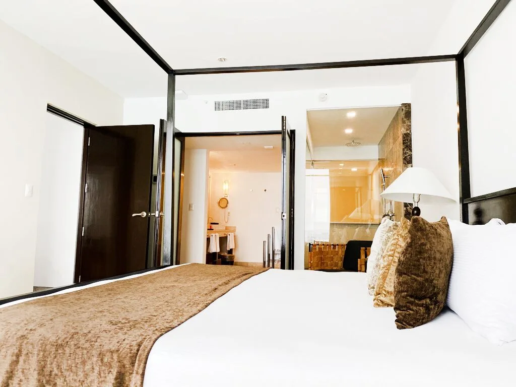 Presidential Room Ocean View king bed with bathroom visible at Krystal Grand Cancun.